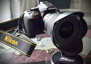 Nikon DSLR camera on glass top table HD wallpaper