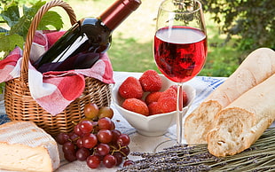wine glass with red wine near wine bottle on wicker basket HD wallpaper