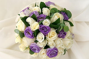white and purple rose bouquet on white textile