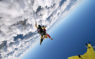 two person flying above white clouds during daytime