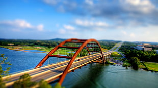 suspension bridge across body of water under cloudy sky at daytime