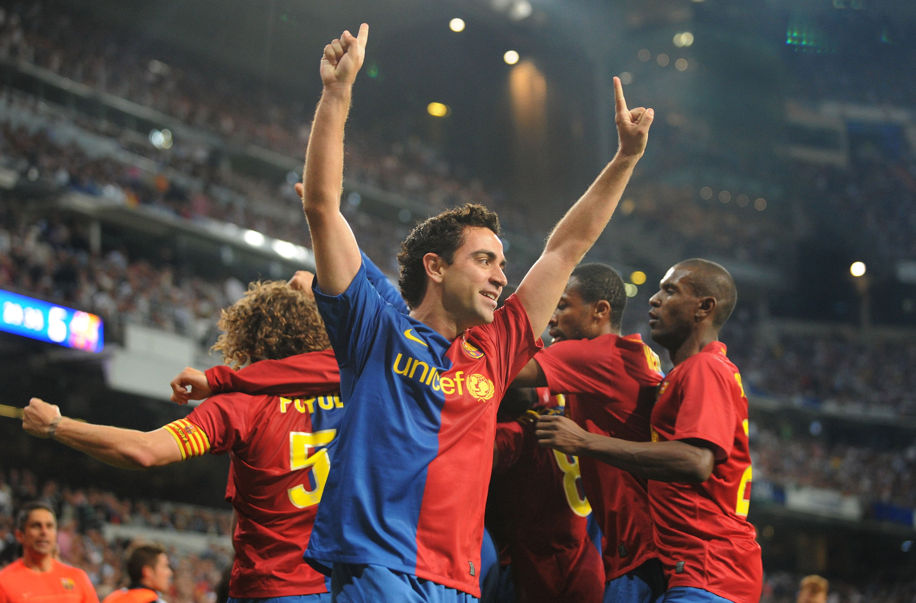 UNICEF soccer player wearing red and blue jersey raising his two hands