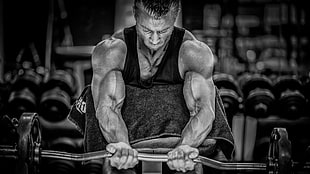 grayscale photo of man lifting barbell