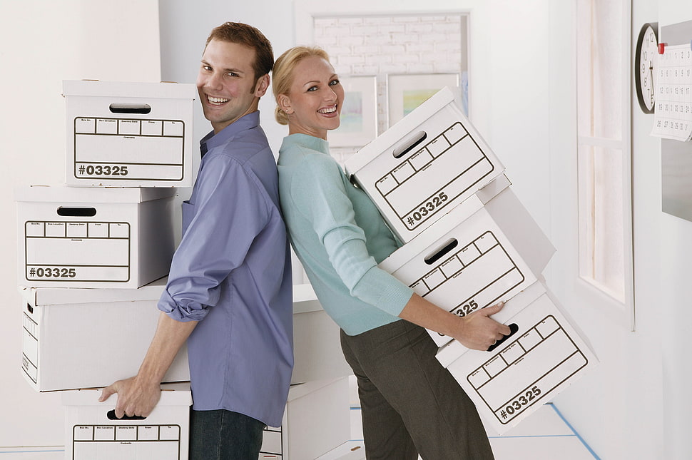 man and woman holding white boxes HD wallpaper