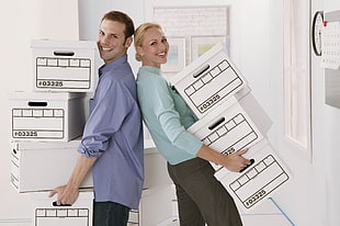 man and woman holding white boxes