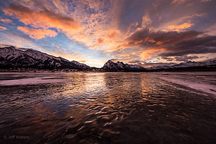 body of water and mountains in sunset photography
