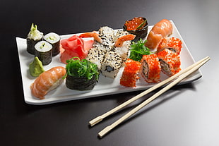 assorted sushi on white ceramic plate with chopsticks