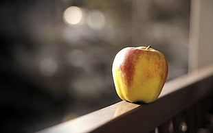 yellow and red apple on gray wooden frame