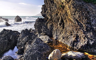 landscape photography of splashing waves on rocks during daytime