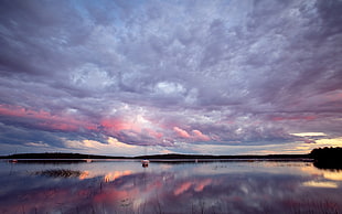 reflection of white clouds on body of water under white clouds