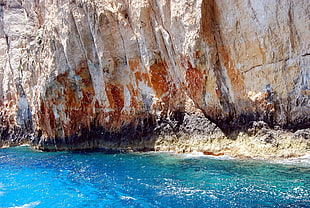 brown rock formation near body of water photo taken during daytime HD wallpaper