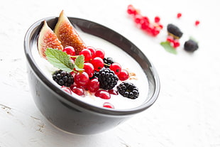 cherries and cranberries on black ceramic bowl