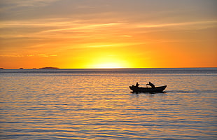 boat on calm sea with man and child during golden hour HD wallpaper