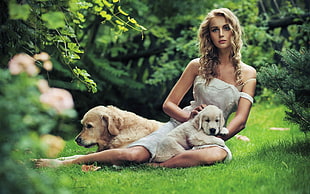 selective focus photography of woman in white dress near two dogs