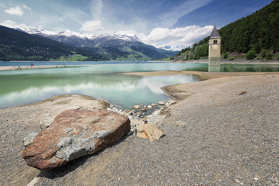 gray stone near river surround by mountains under blue sky HD wallpaper