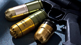 three gold-colored containers, gun, ammunition, grenade launchers, 40MM Grenade