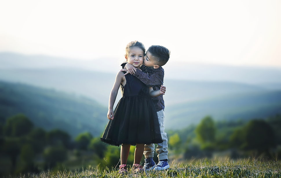 selective focus photography of boy kissing and hugging girl HD wallpaper