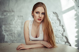 woman wearing white tank top in front of table