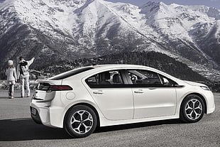 grayscale photography of white 5-door hatchback near man and woman HD wallpaper