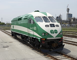 green and white 601 train near gray industrial machine during daytime HD wallpaper