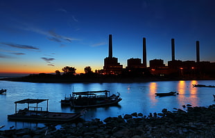 Industrial buildings and boats silhouette during sunrise HD wallpaper