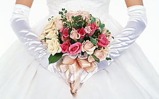 person wearing bouquet of pink and peach rose flowersa