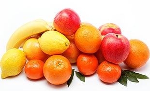 red apples, orange fruits, and limes with bananas
