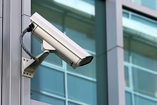 selective focus photography of grey security camera mounted outside building