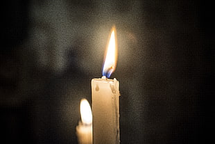 selective focus photography of lighted taper candle