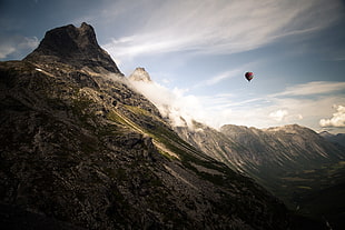 hot air balloon in air near mountain during daytime HD wallpaper