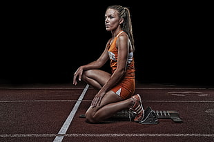 woman wearing orange tracksuit on track field