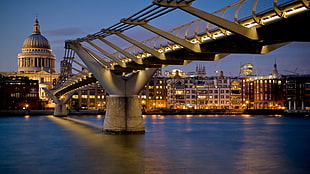 concrete sea bridge with rise buildings on side during night time