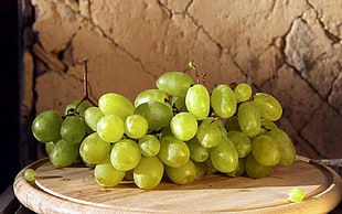 bundle of green grapes on brown wooden table