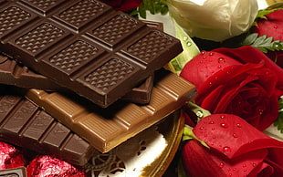 chocolate bars beside red roses