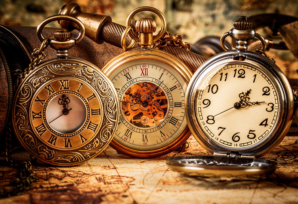 three gold-colored pocket watches displaying 12:00, 11:05, and 1:13 HD wallpaper