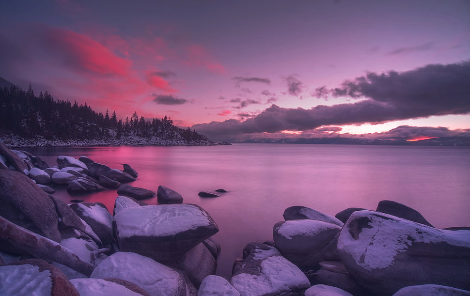 panaroma photography of rocks and body of water under nimbus clouds during golden hour HD wallpaper