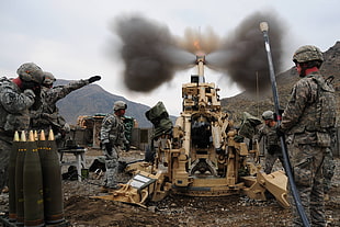 soldiers firing the brown metal canon during daytime HD wallpaper