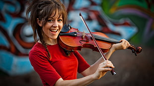 woman wearing red shirt and holding violin