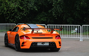 orange and black sports coupe at the road