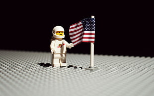 close up photo of astronaut lego minifigure and american flag toy