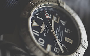 round silver Breitling analog watch
