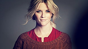 woman wearing red top and knitted brown boat-neck sweater