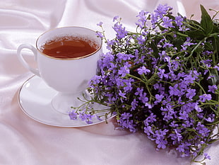 white ceramic coffee mug and saucer with purple flowers