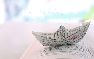 Paper boat on book page