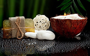 white soap beside coconut shell with candle