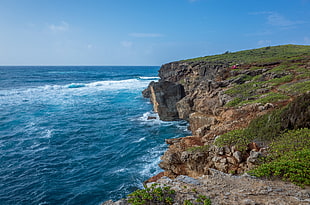 photography of cliff and sea under blue sky, poipu