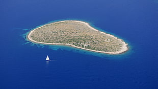 aerial photography of beige island with yacht during daytime HD wallpaper