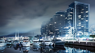 yachts near buildings during nighttime