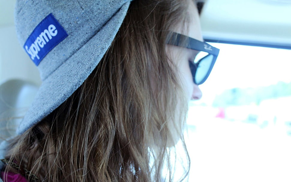 closeup photo of woman wearing gray Supreme cap and black Ray-Ban sunglasses HD wallpaper