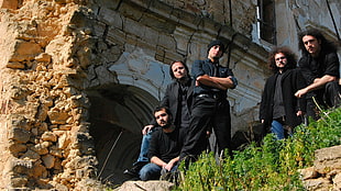 five men standing under grey stone building during daytime HD wallpaper